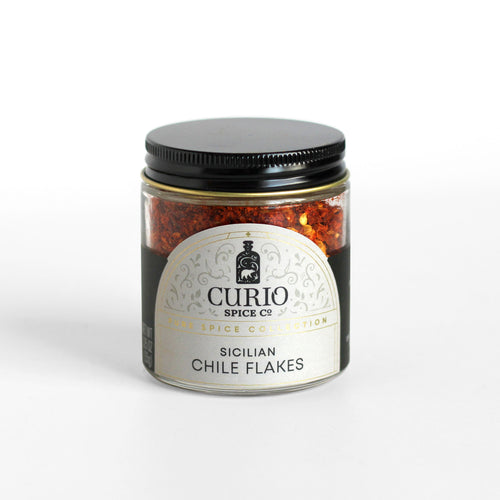 Curio Spice Co. fair-trade single origin sustainable Sicilian Chile Flakes in a glass jar.