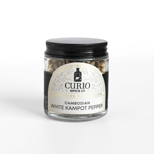 Curio Spice Co. fair-trade single origin sustainable Cambodian White Kampot Pepper in a glass jar.