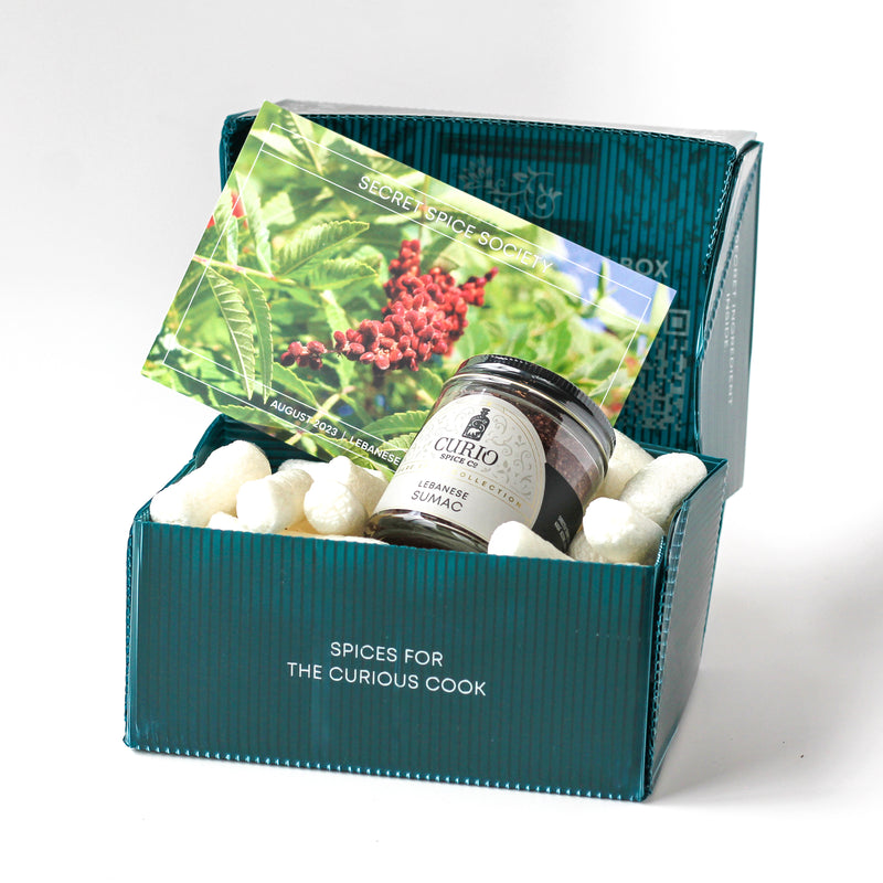 Curio Spice Co. Secret Spice Society subscription box with Lebanese Sumac in a glass jar and postcard.